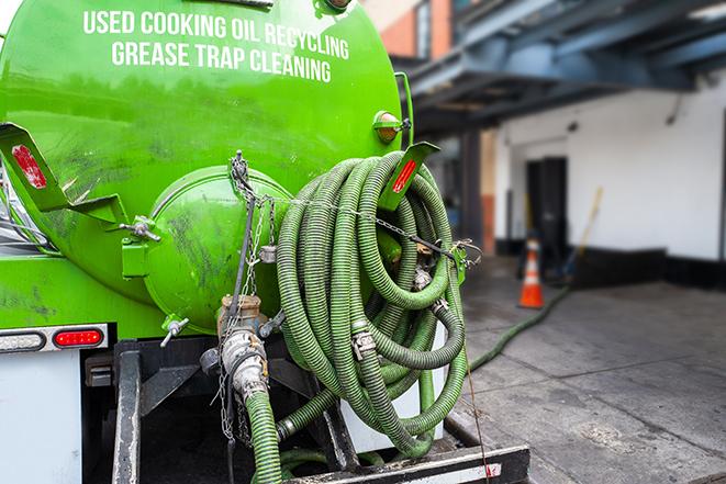 large truck pumping grease trap at a restaurant in Brighton MA